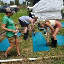 Team members painting wood